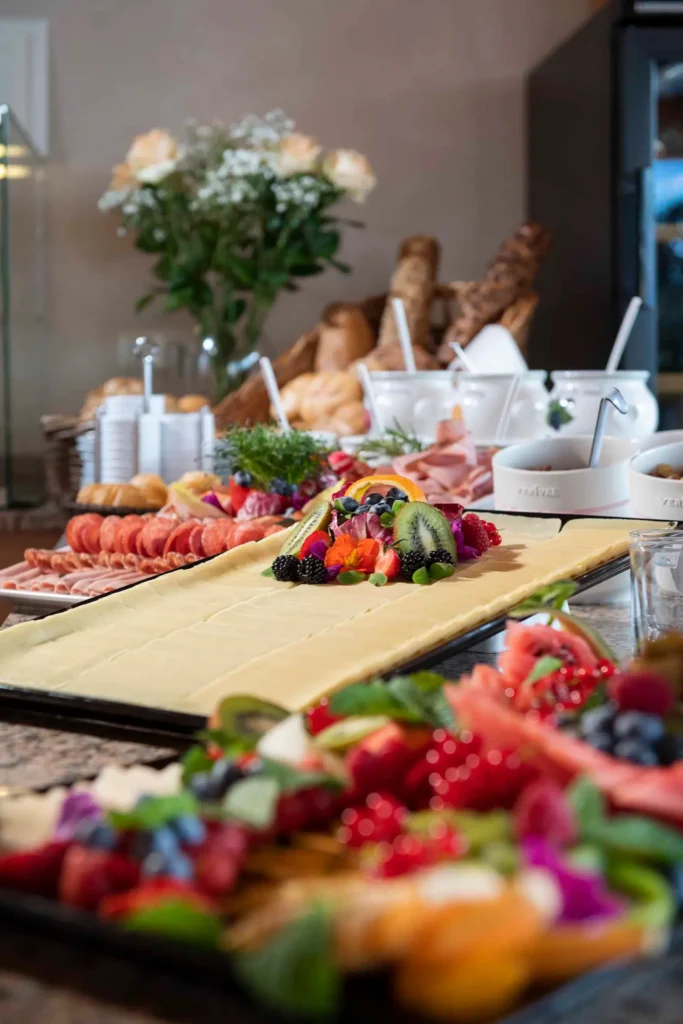 Frische Käse- und Obstplatten sowie Gebäck am reichhaltigen Frühstücksbuffet des Hotel Hubertushof.